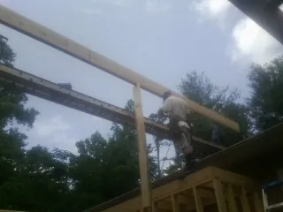Carpenter setting a ridge beam over a new addition frame — Ice Dam Removal by Roofing Brothers in Minster