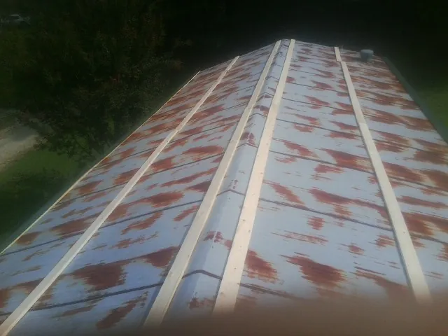 Rusted metal roof panels with new wood purlins before replacement — Storm Damage Roof Repair in Minster by Roofing Brothers