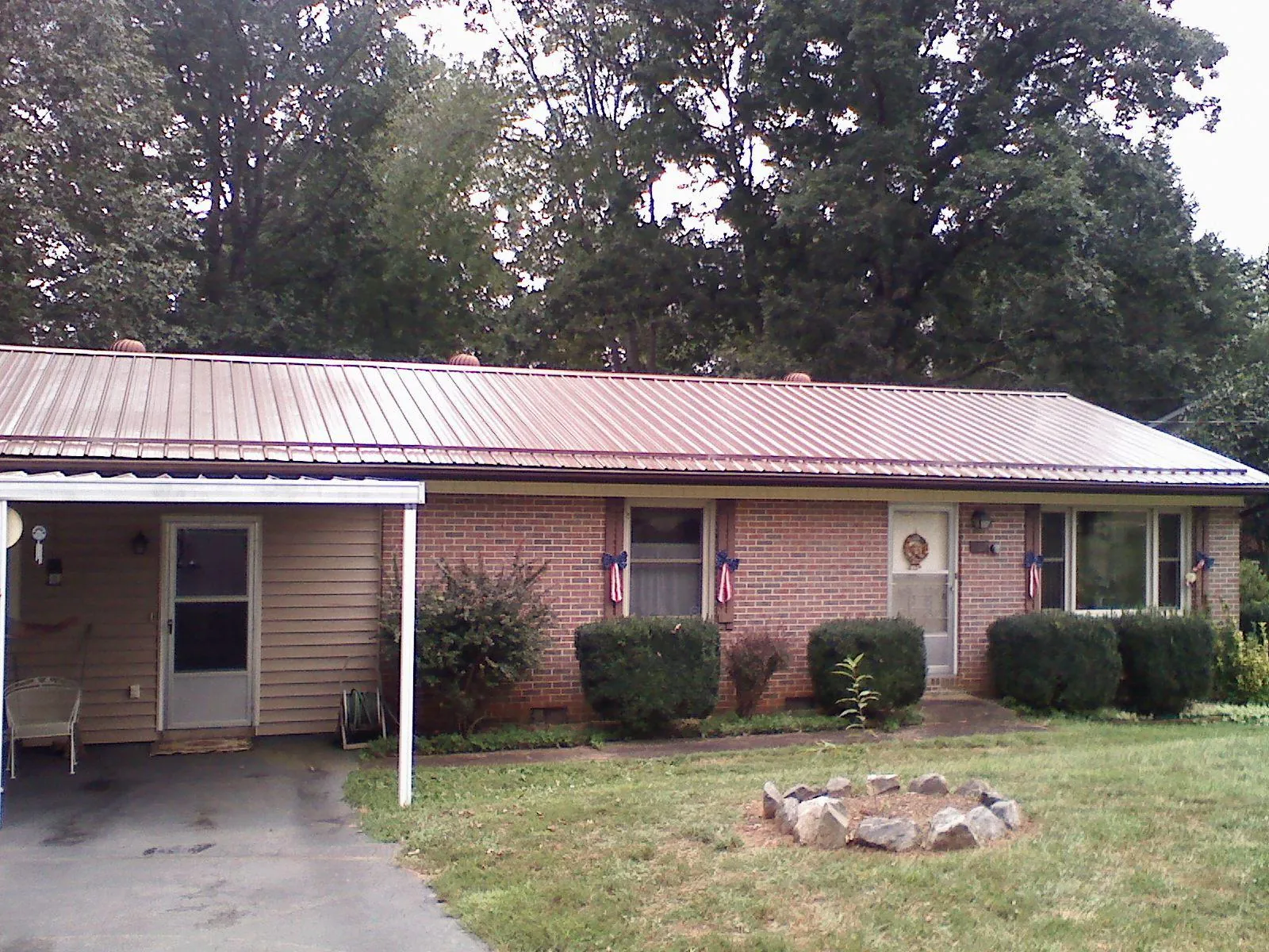 Bronze metal roof and carport on a brick ranch home — Roof Repair work by our crew in Minster